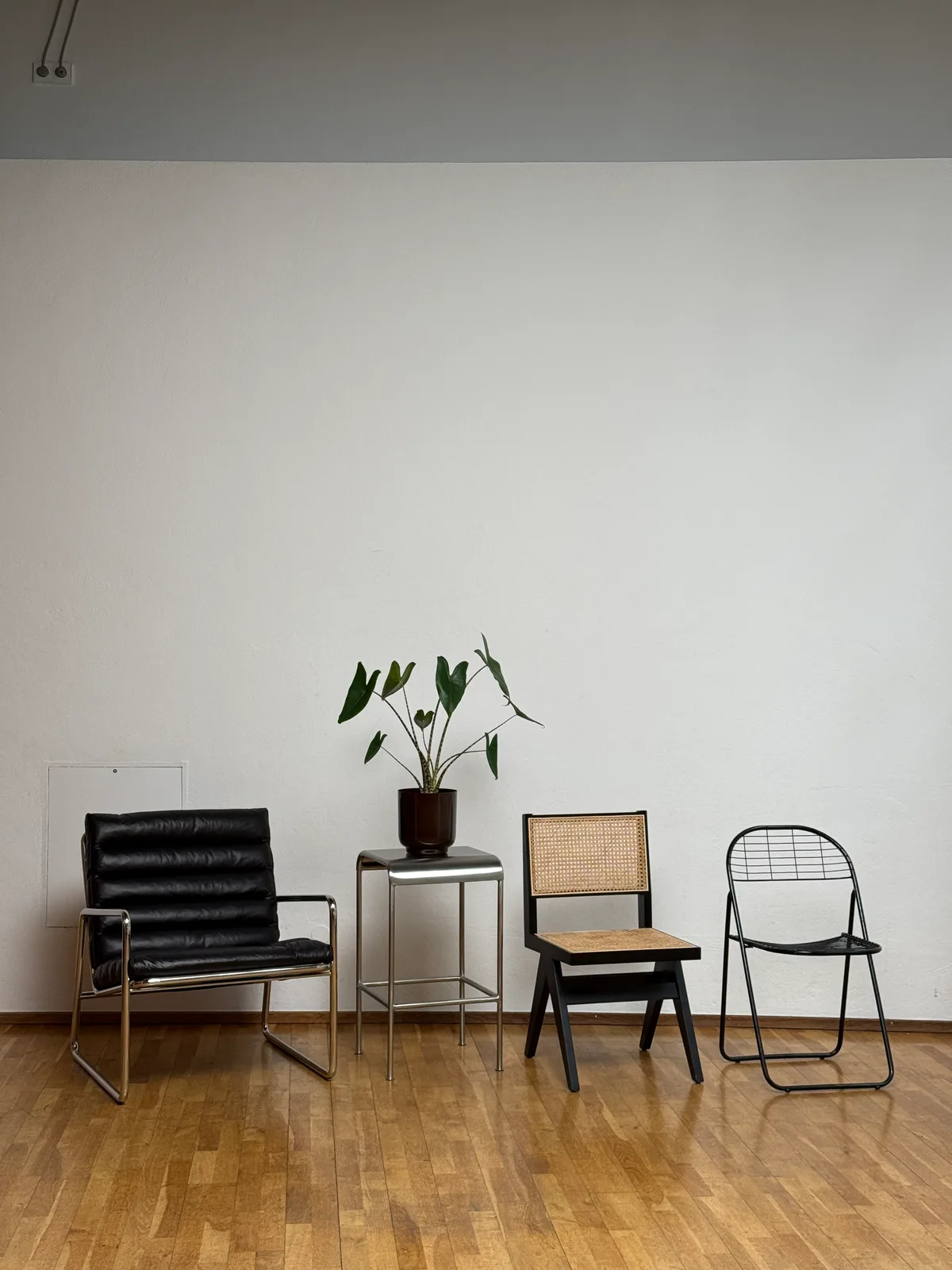 Styling-Ecke im Studio mit Spiegel, Pflanzen und Deko-Objekten vor heller Wand