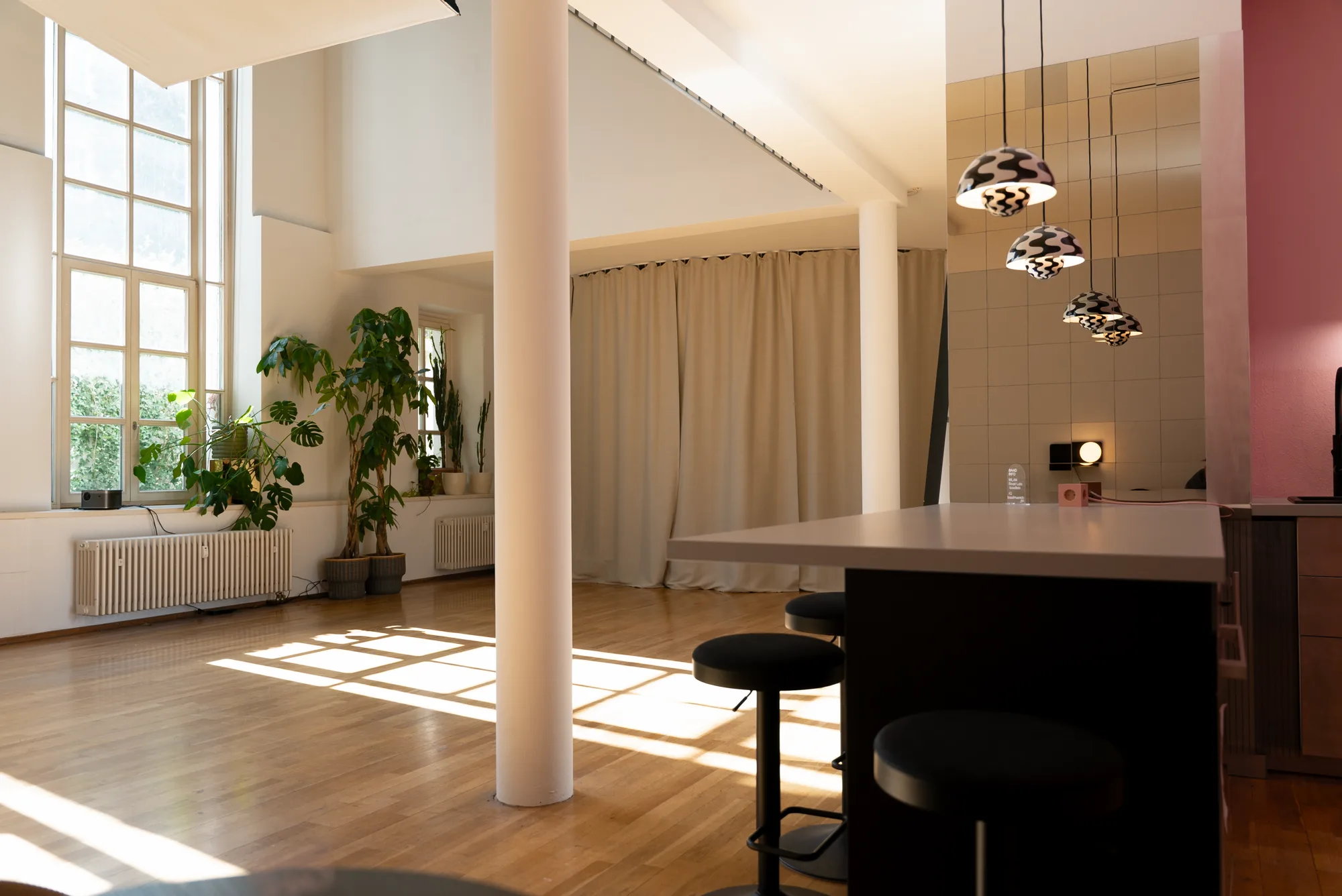 Studiofläche mit hohen Fenstern, Säule und Küchentheke
